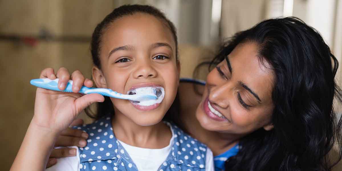 Parent brushing infant's teeth